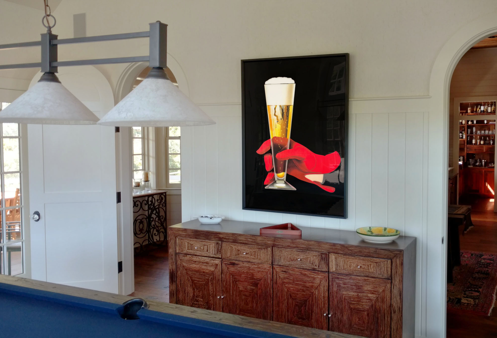 framed poster of red gloved hand holding beer glass above sideboard; brown, blue, red, yellow