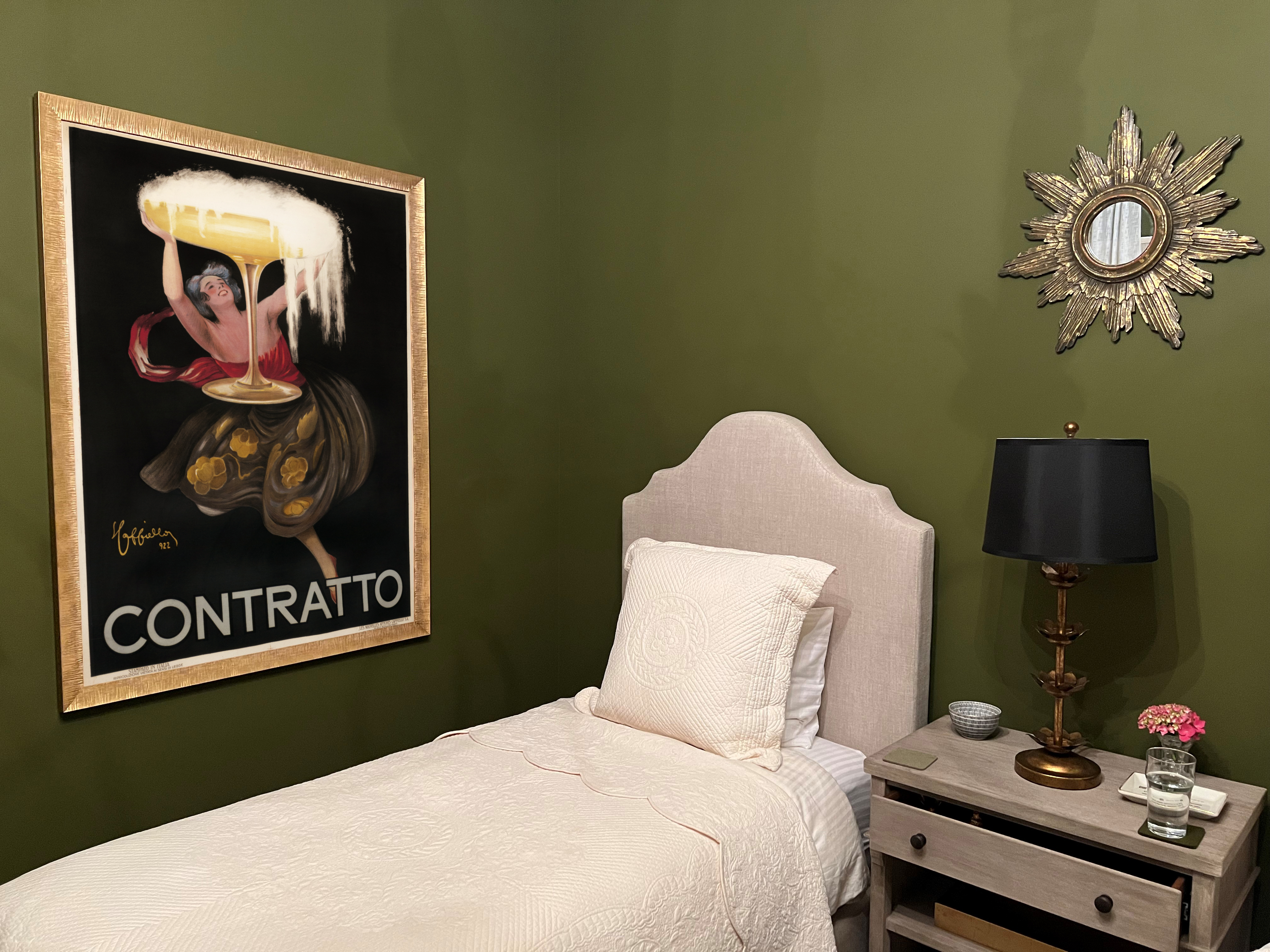 poster of woman holding champagne framed in bedroom